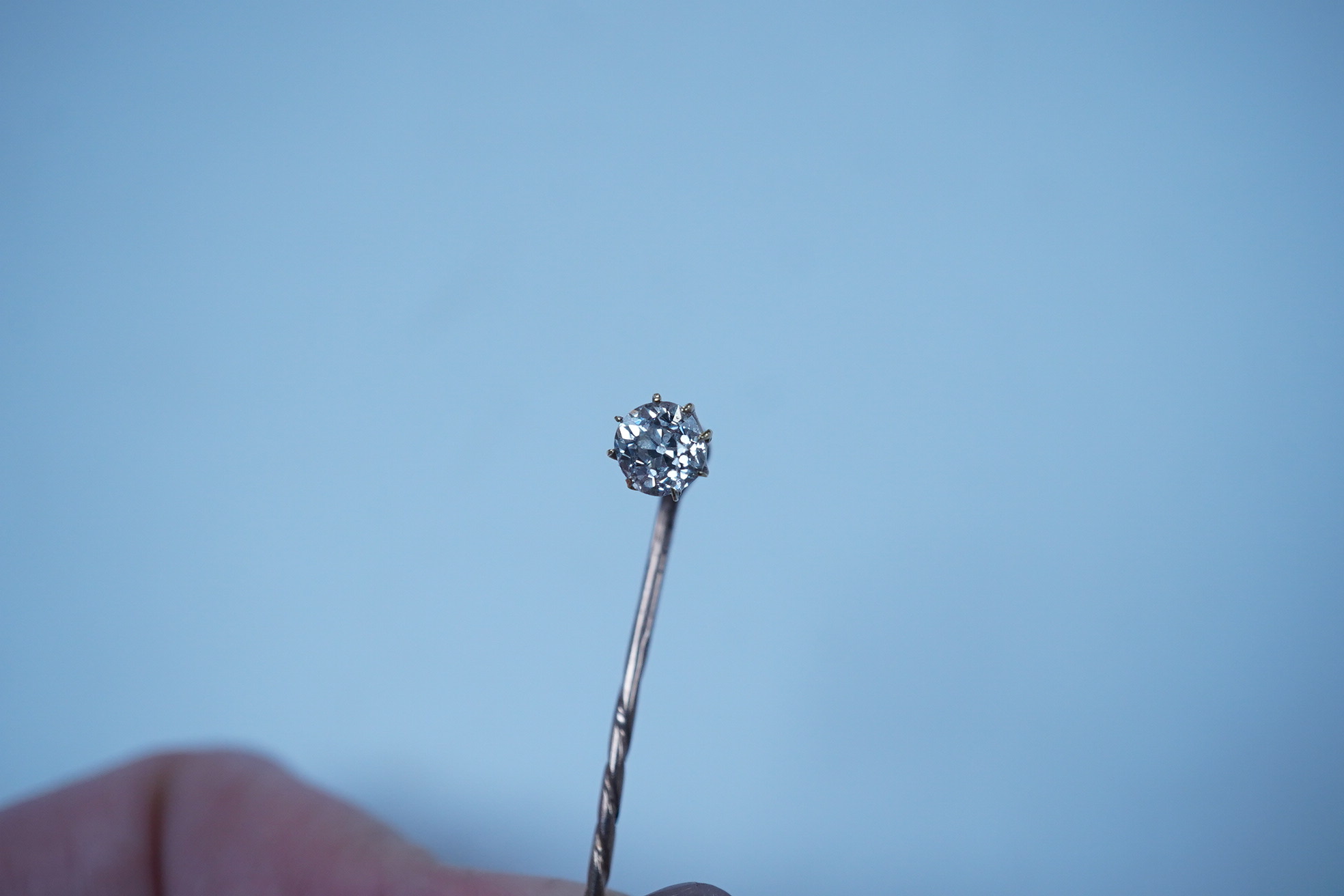 A yellow metal and solitaire diamond set stick pin, the stone diameter approx. 5mm, 59mm, gross weight 2.3 grams. Condition - fair to good